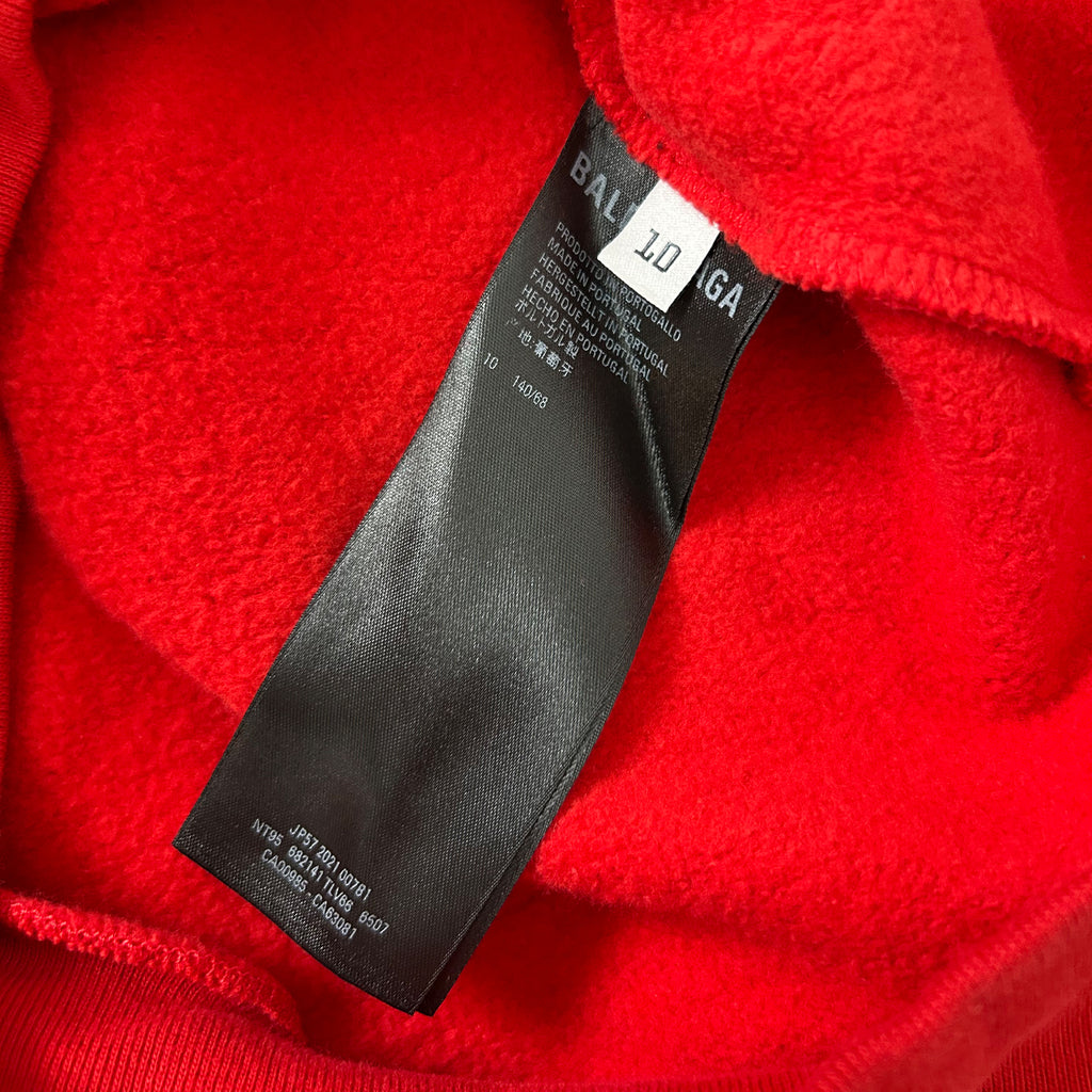 A close-up view of a red fabric with a black label attached to it.