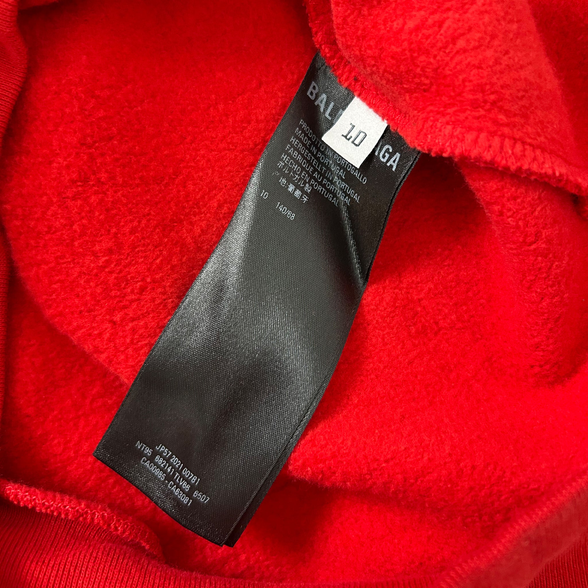 A close-up view of a red fabric with a black label attached to it.