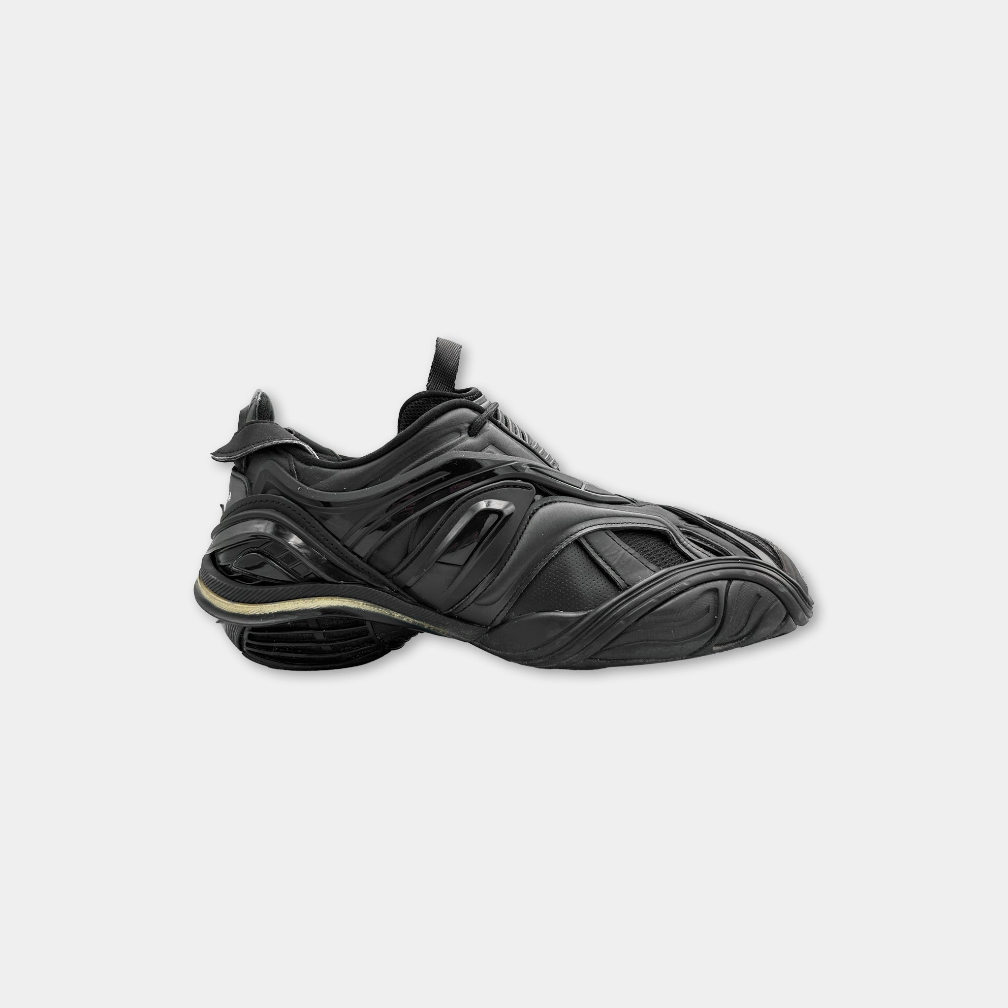 A black and gold sneaker with a distinctive design.