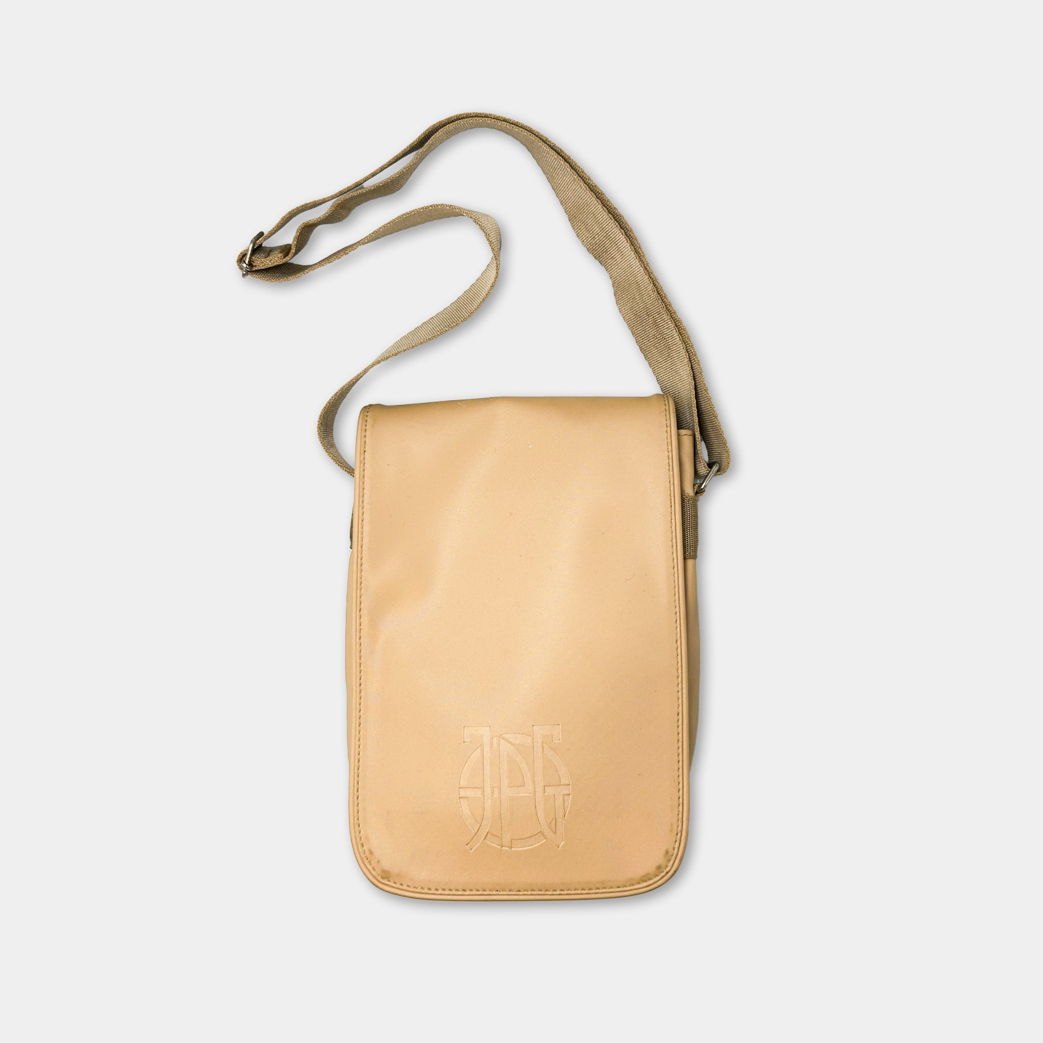 A tan leather crossbody bag with a beige strap and a logo on the front.