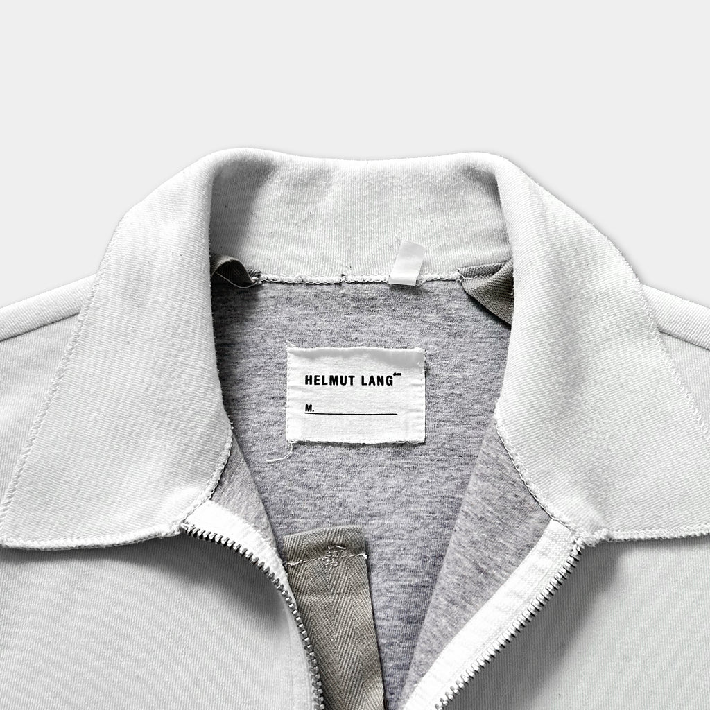 A close-up view of a white jacket with a label on the collar.