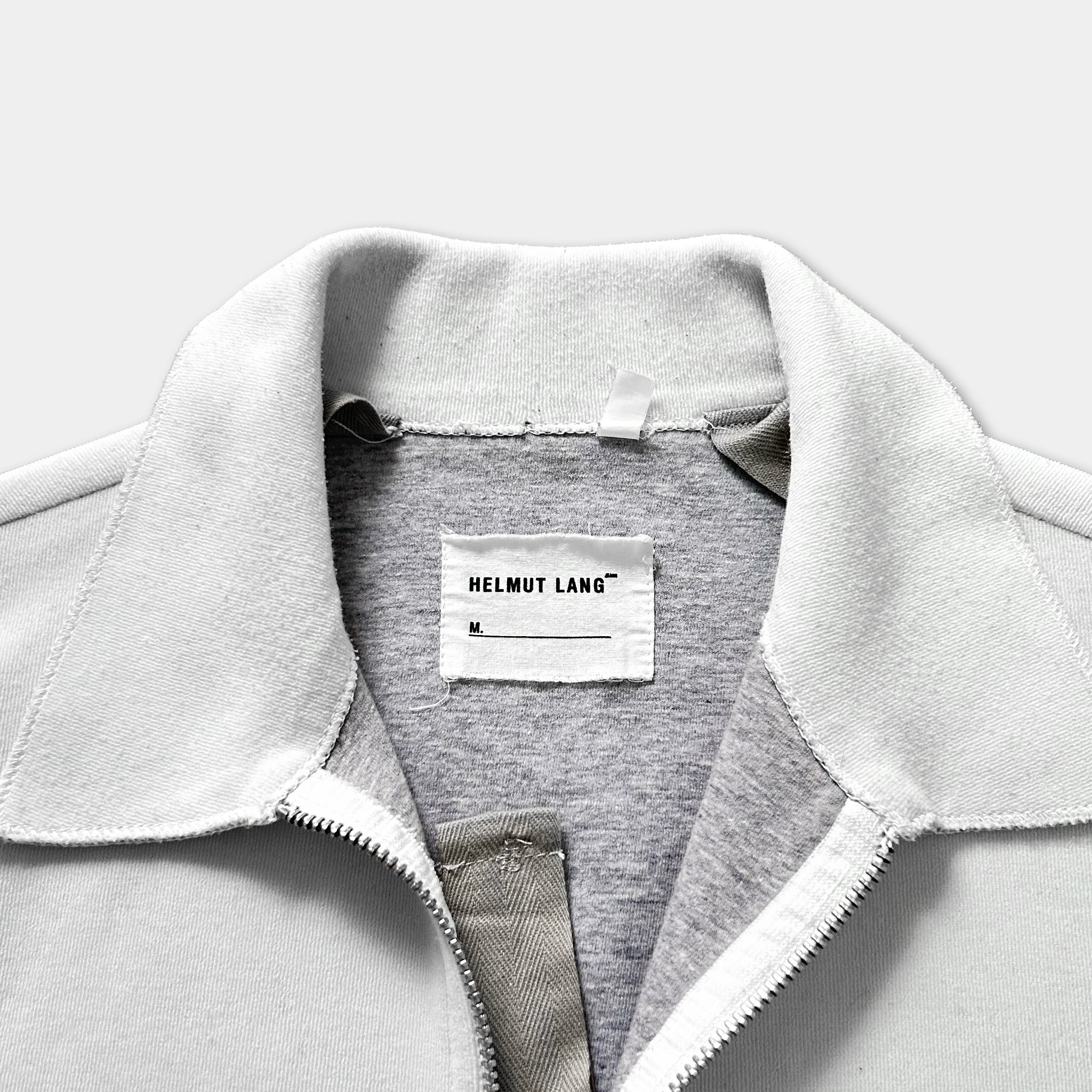 A close-up view of a white jacket with a label on the collar.