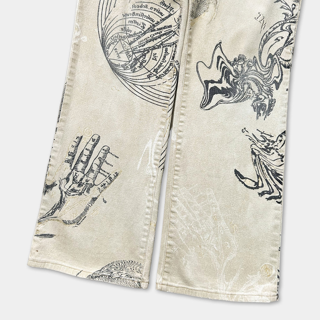 a pair of beige jeans with various black and white illustrations and designs printed on them.