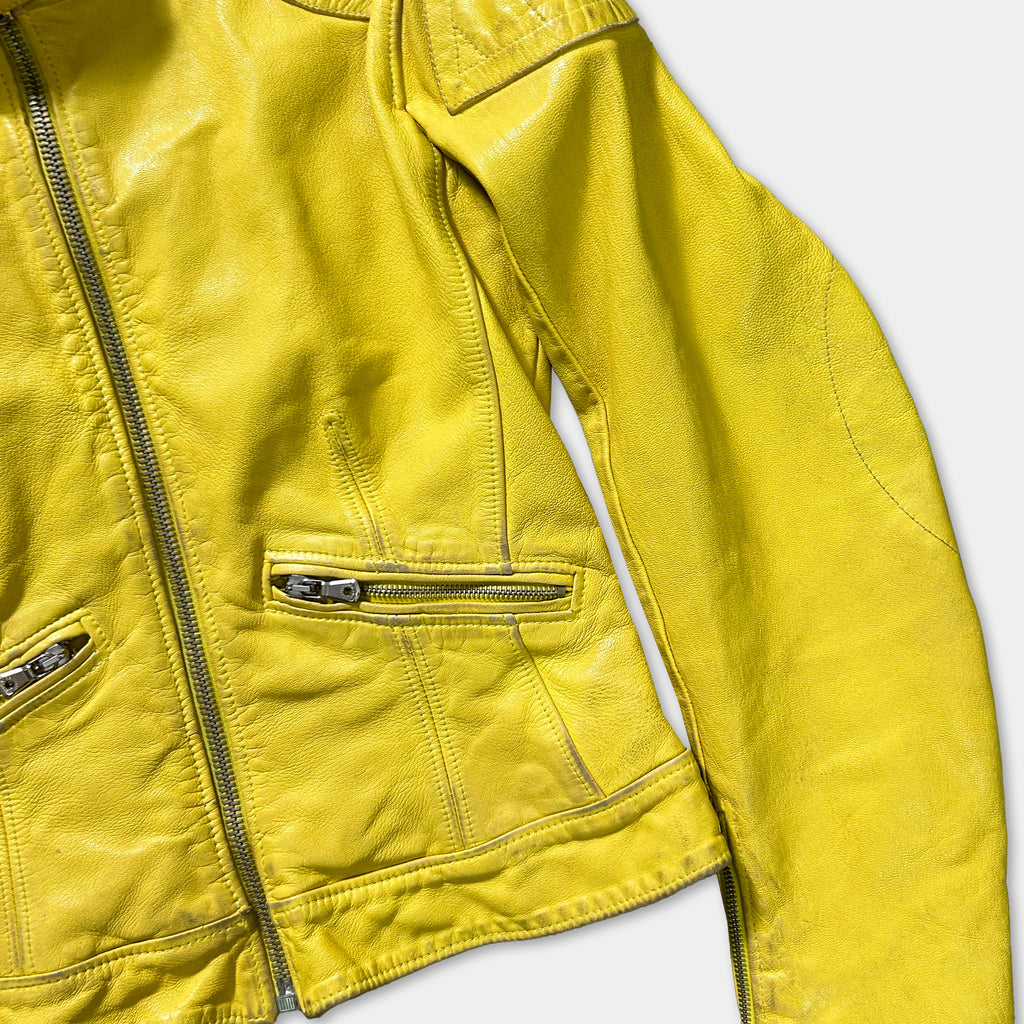 A close-up view of a bright yellow leather jacket with a zipper and two pockets.