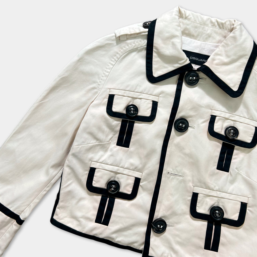 A white jacket with black trim and buttons, featuring multiple pockets and a collar.