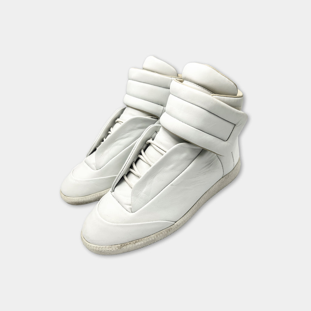 A pair of white high-top sneakers with a distinctive design.