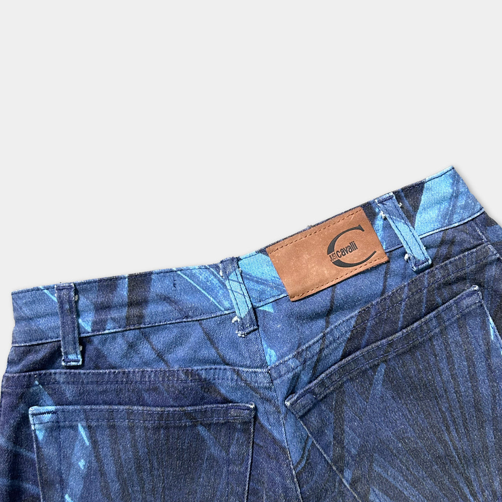 A pair of blue jeans with a patterned design and a leather patch on the waistband.