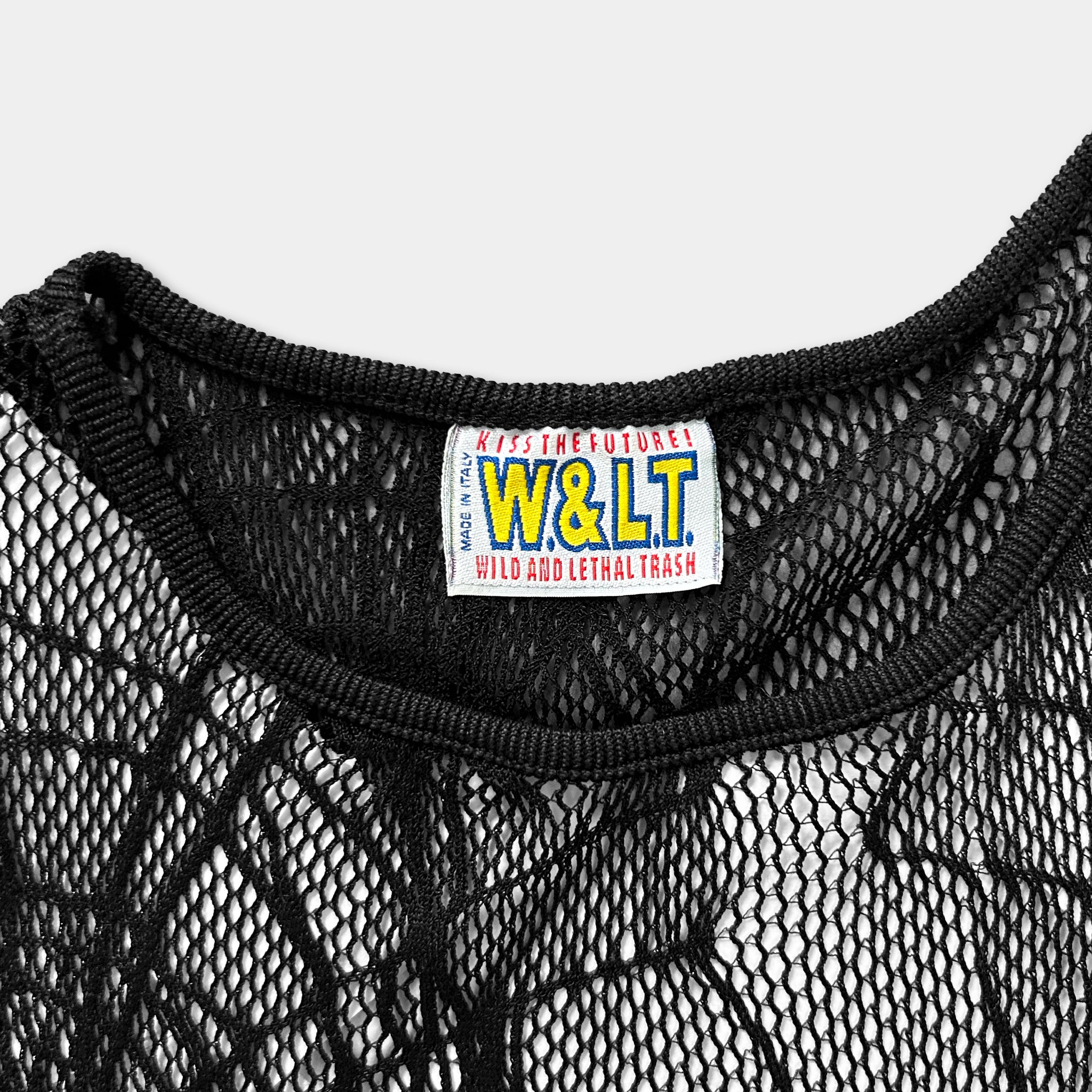 A close-up view of a black mesh garment, with a label on the collar that reads "W&LT WILD AND LETHAL TRASH".