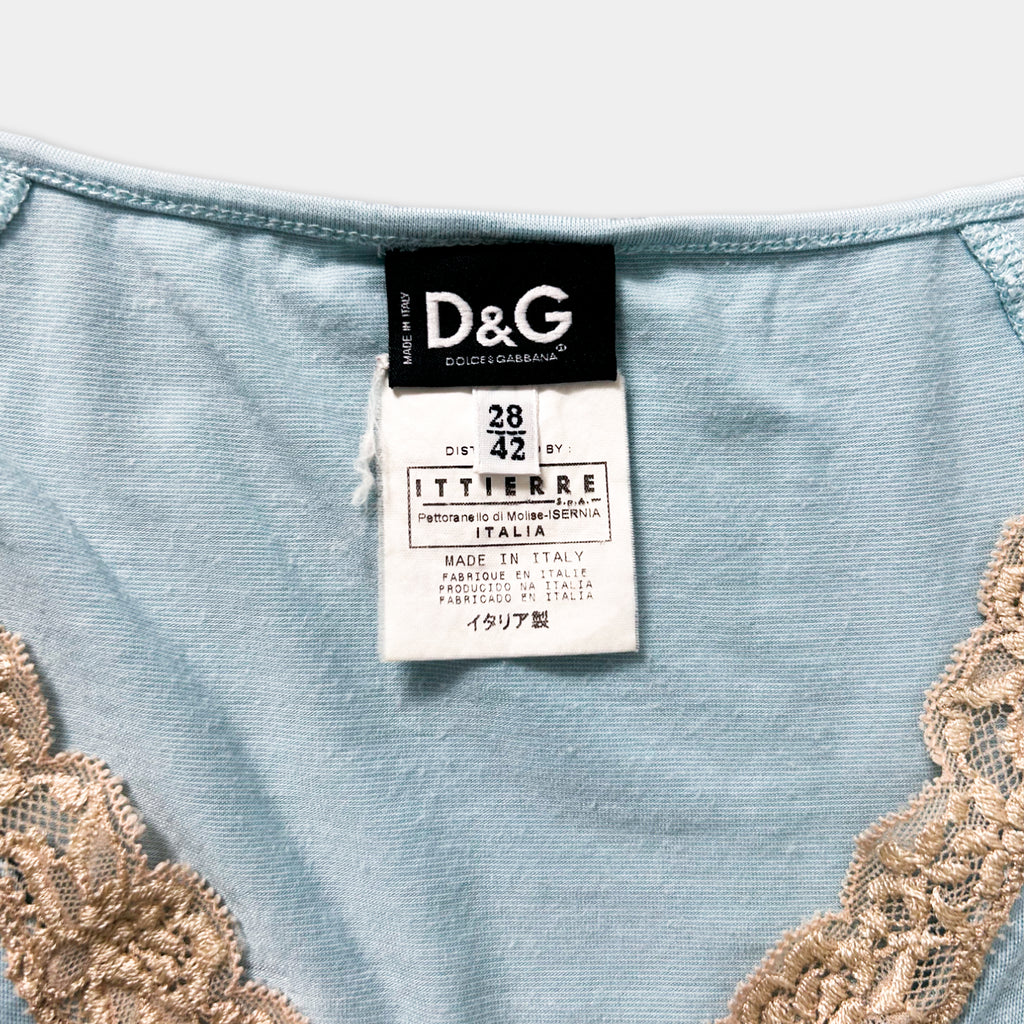 A close-up of a light blue garment with a label attached, featuring lace details.
