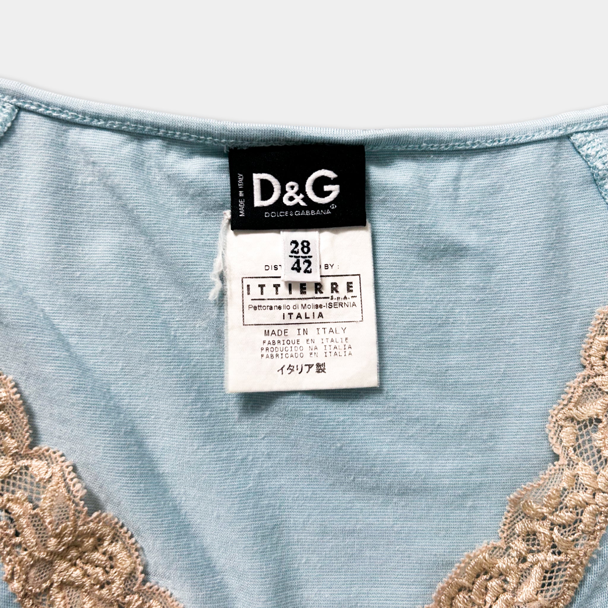 A close-up of a light blue garment with a label attached, featuring lace details.