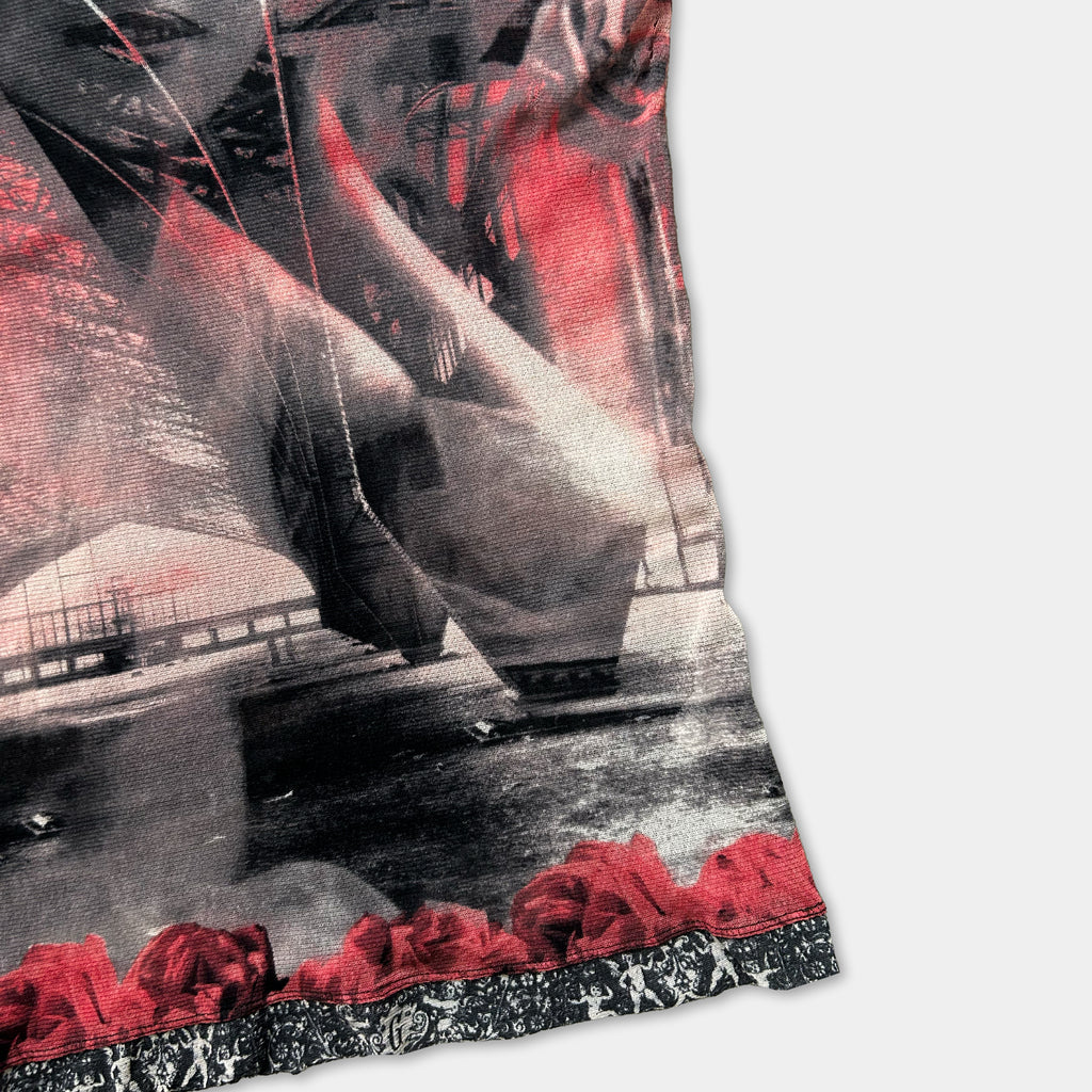 The image is a close-up of a printed fabric with a striking black and red color scheme. The fabric features a floral pattern on the border, adding a touch of elegance to the design. The image is a collage of various images, creating a visually captivating and artistic composition.
