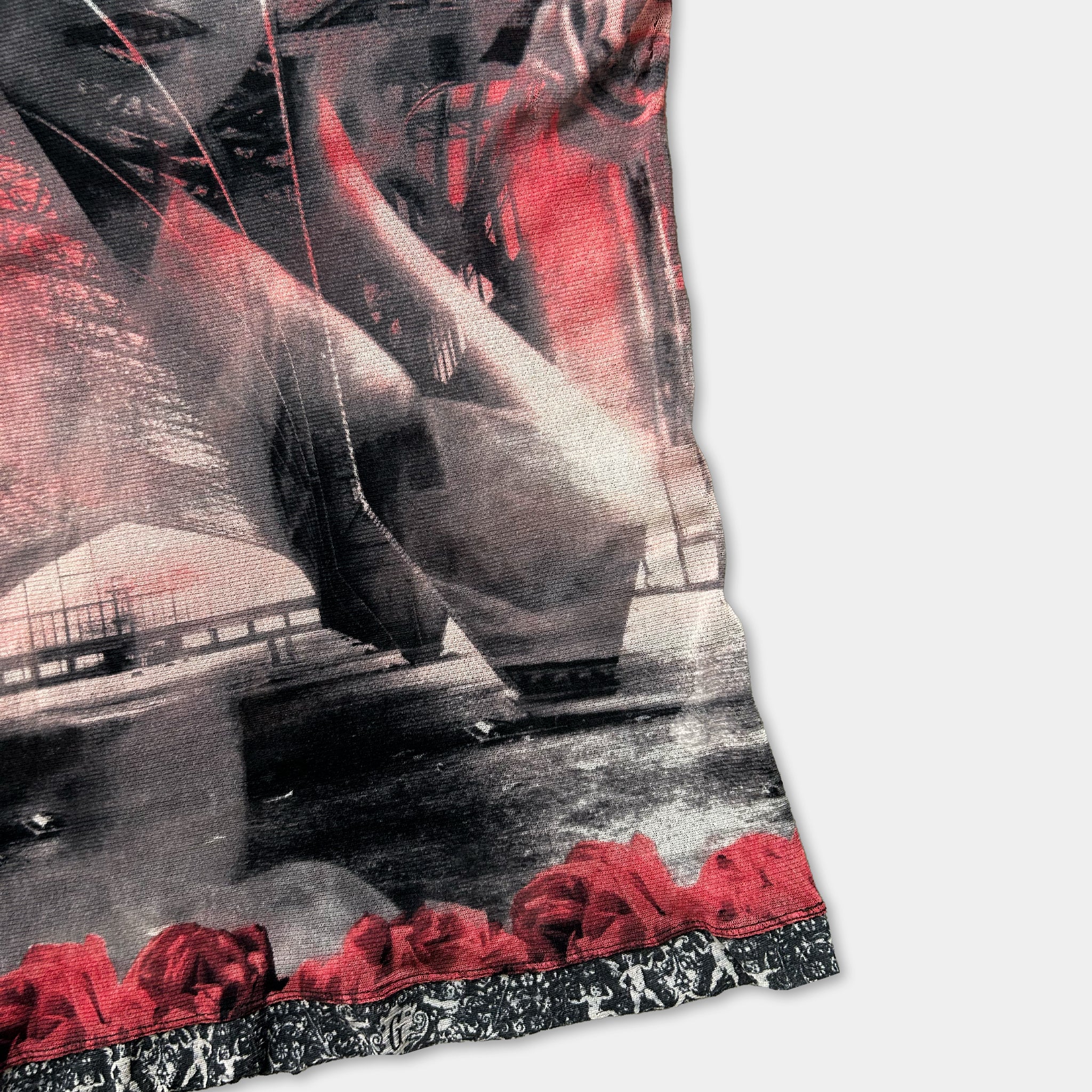 The image is a close-up of a printed fabric with a striking black and red color scheme. The fabric features a floral pattern on the border, adding a touch of elegance to the design. The image is a collage of various images, creating a visually captivating and artistic composition.