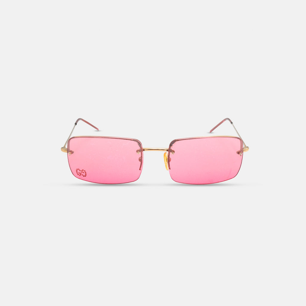 A pair of pink-tinted glasses with gold-colored frames, displayed against a white background.