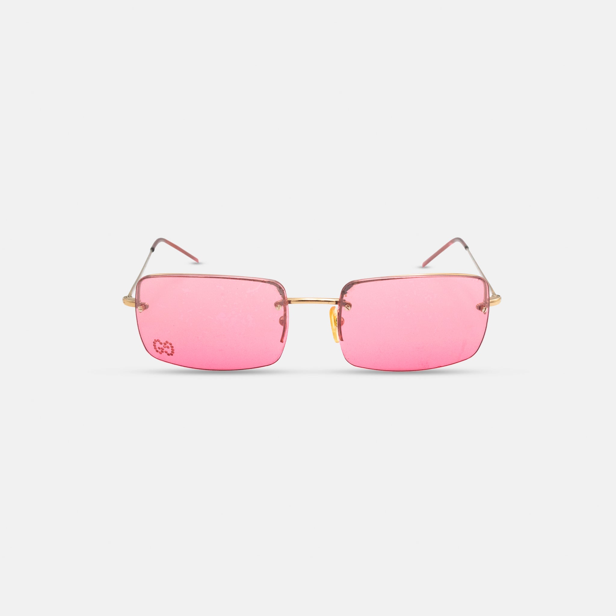 A pair of pink-tinted glasses with gold-colored frames, displayed against a white background.