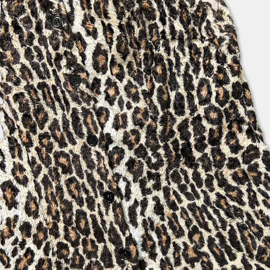 a close-up view of a leopard print fabric, with a pattern of brown and black spots.
