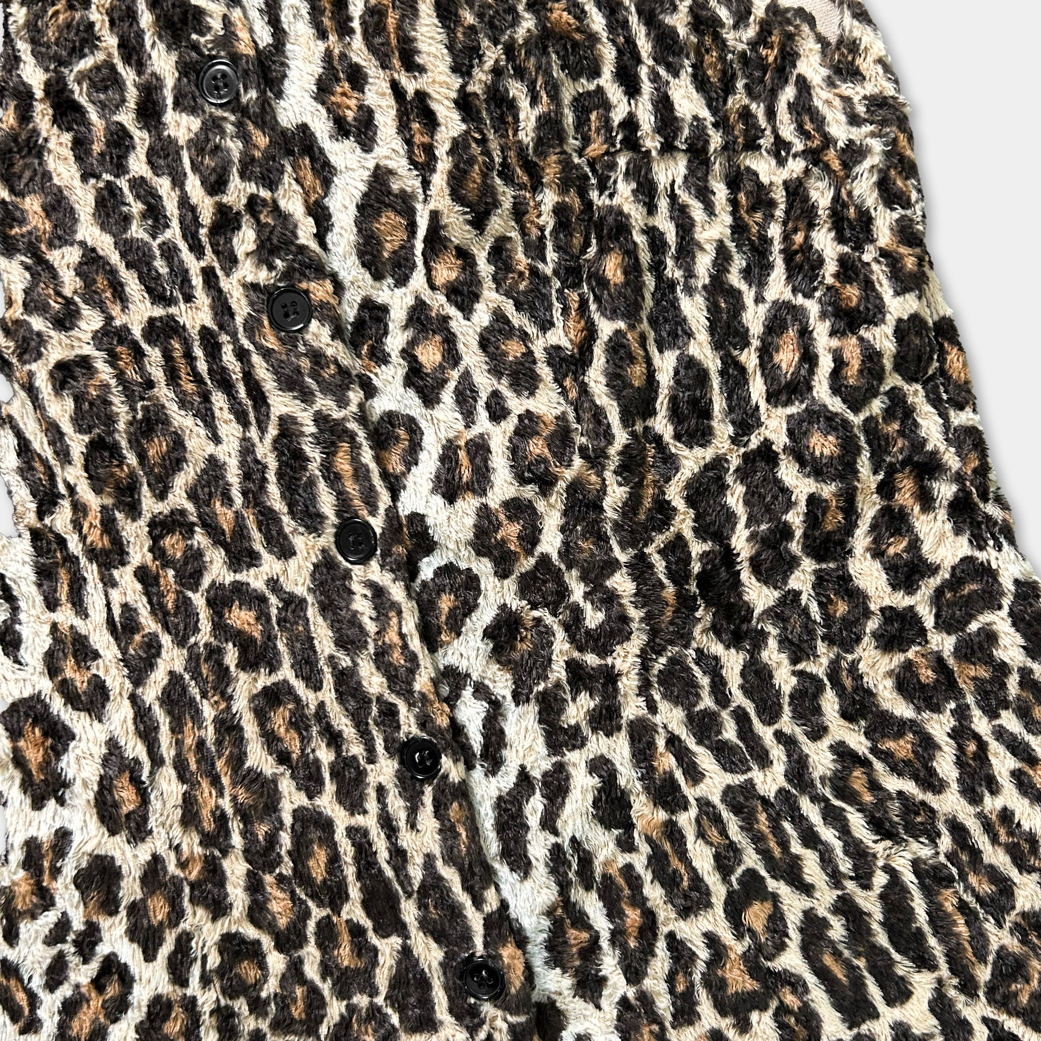 a close-up view of a leopard print fabric, with a pattern of brown and black spots.