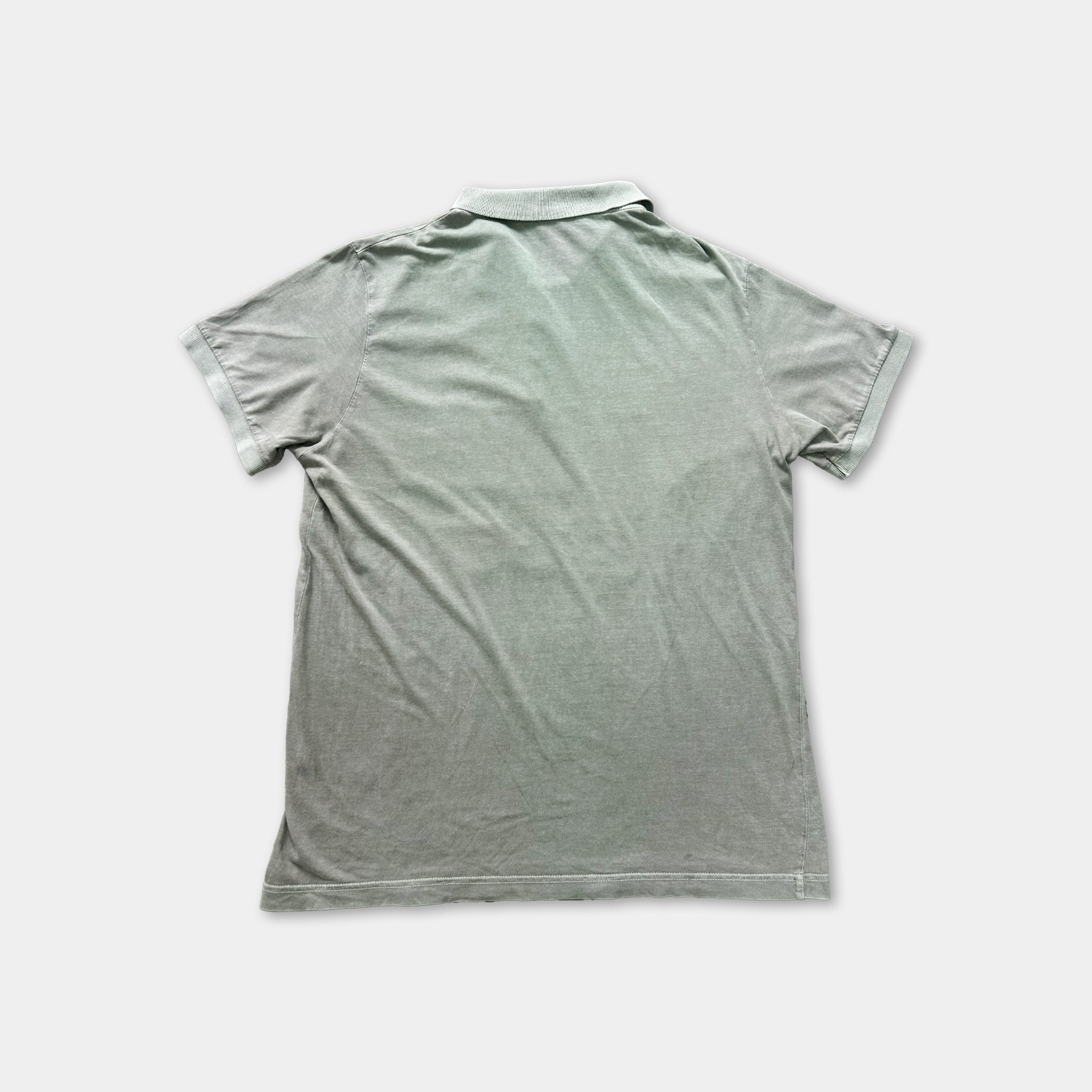 a gray polo shirt laid flat on a white background.