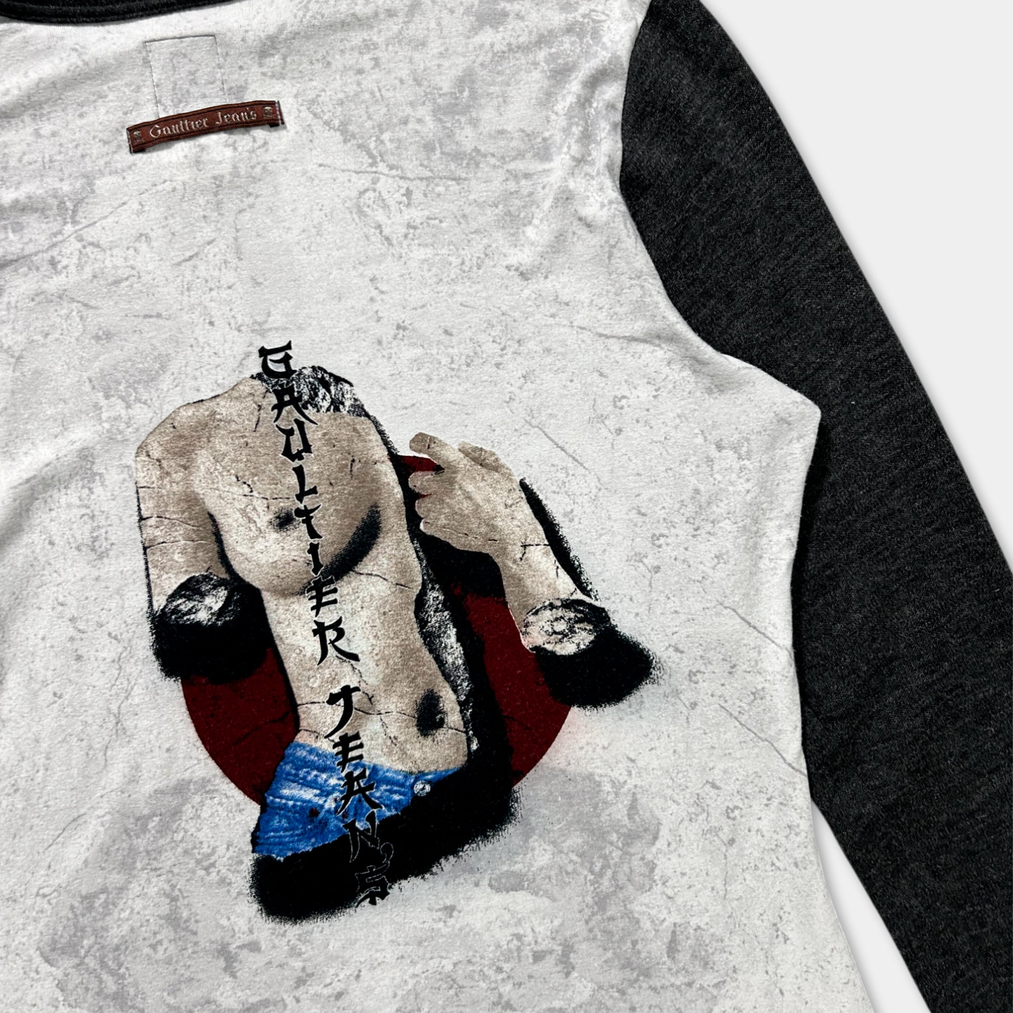 a graphic design on a white and black long-sleeved shirt, depicting a person with a shaved head and a red circle around their chest.