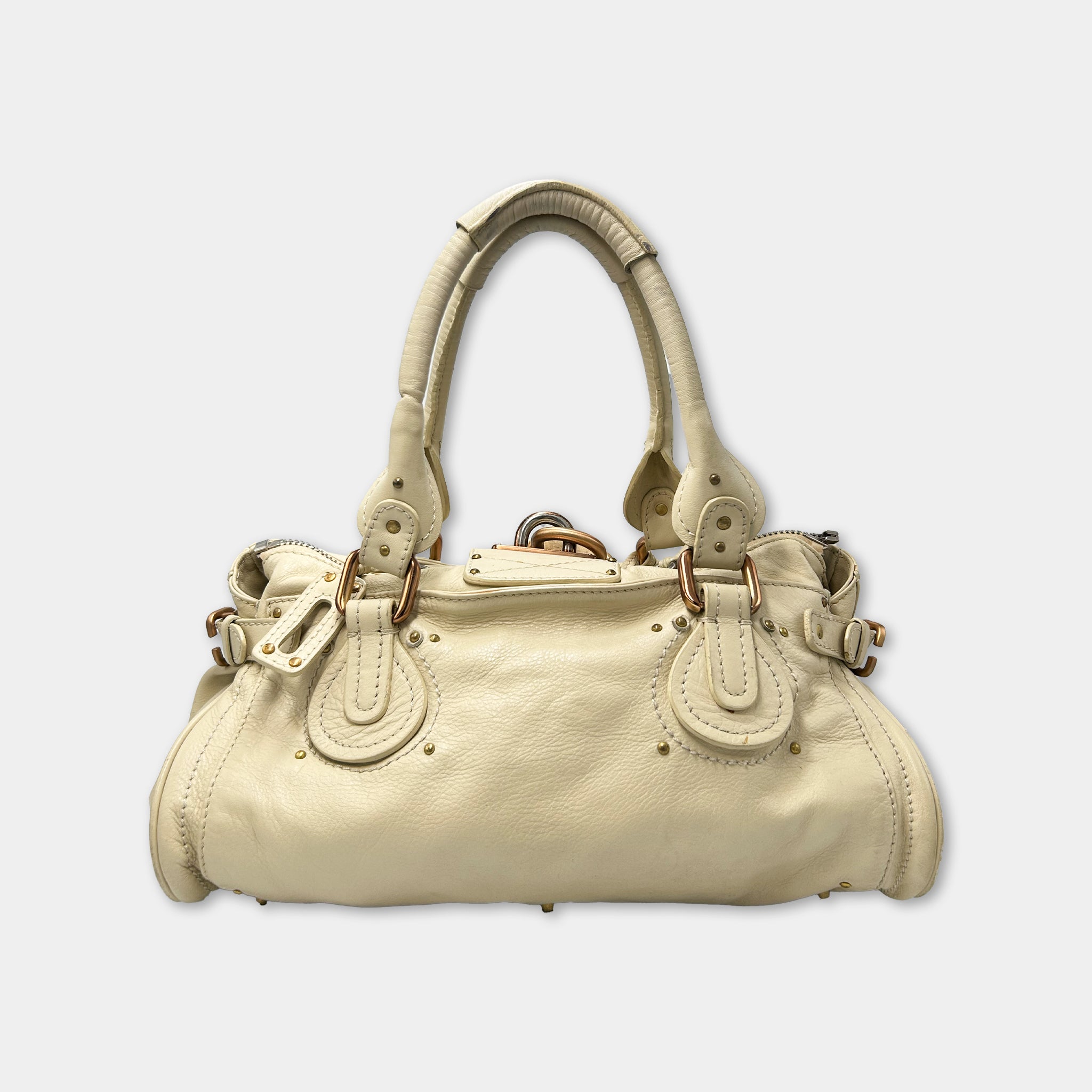 A tan leather handbag with gold hardware and accents.