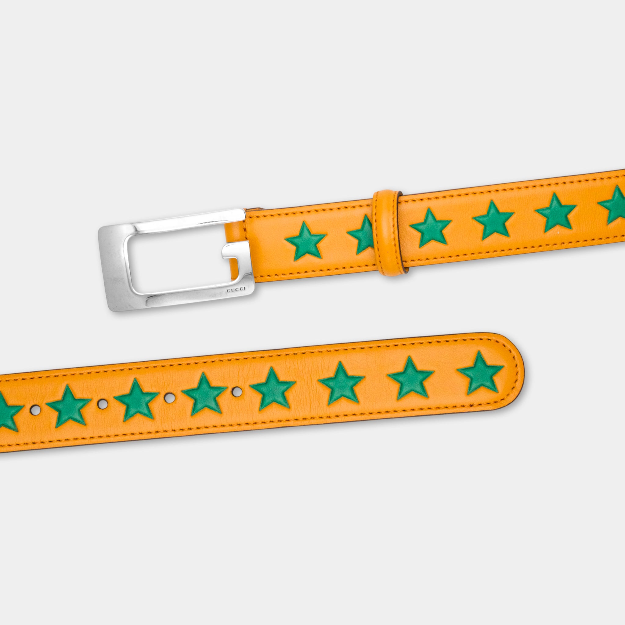 a pair of orange leather belts with green star-shaped embellishments.