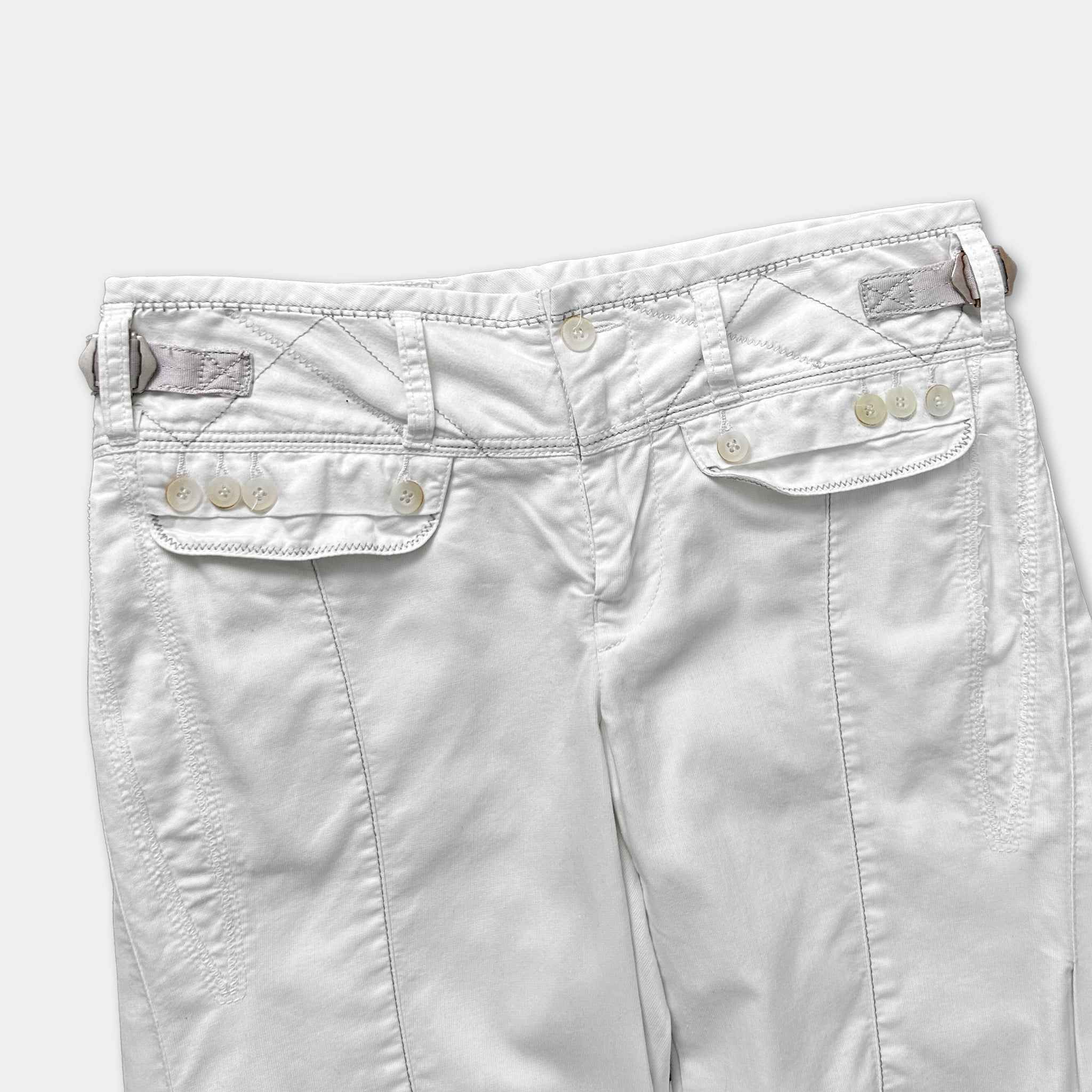 A pair of white pants with a zipper and button closure.