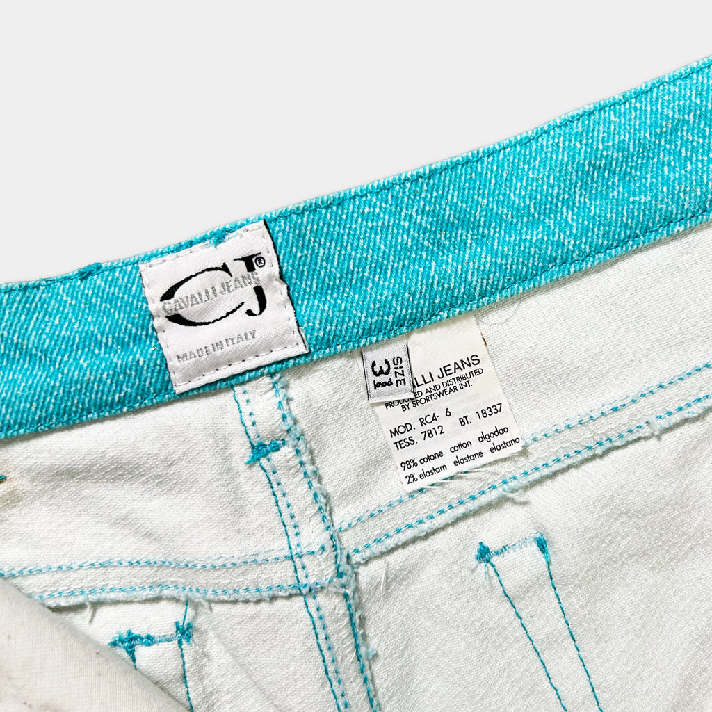 a close-up view of a pair of white jeans with a turquoise waistband. The jeans appear to be made of a soft, comfortable fabric, and there is a label attached to the waistband that provides information about the jeans.
