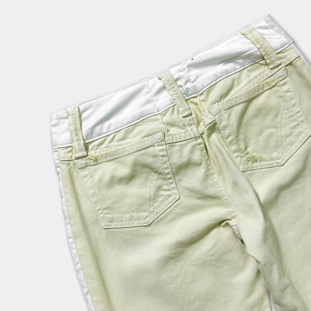 A pair of khaki-colored pants with a white waistband and a small tear in the pocket.