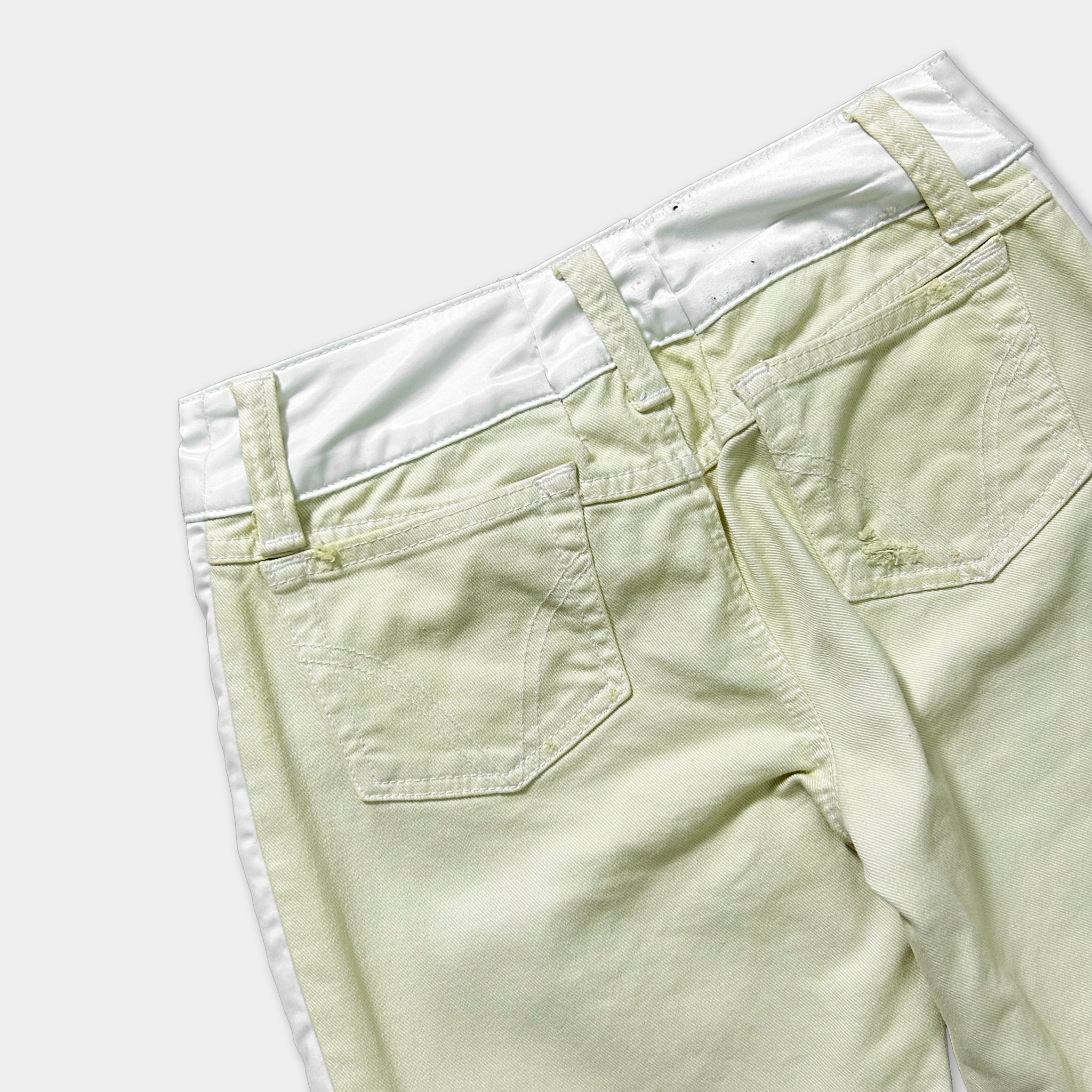 A pair of khaki-colored pants with a white waistband and a small tear in the pocket.