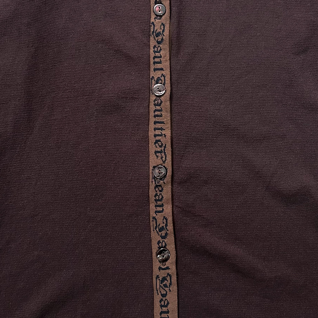 a close-up view of a dark brown fabric with a brown ribbon or strap running vertically down the center.