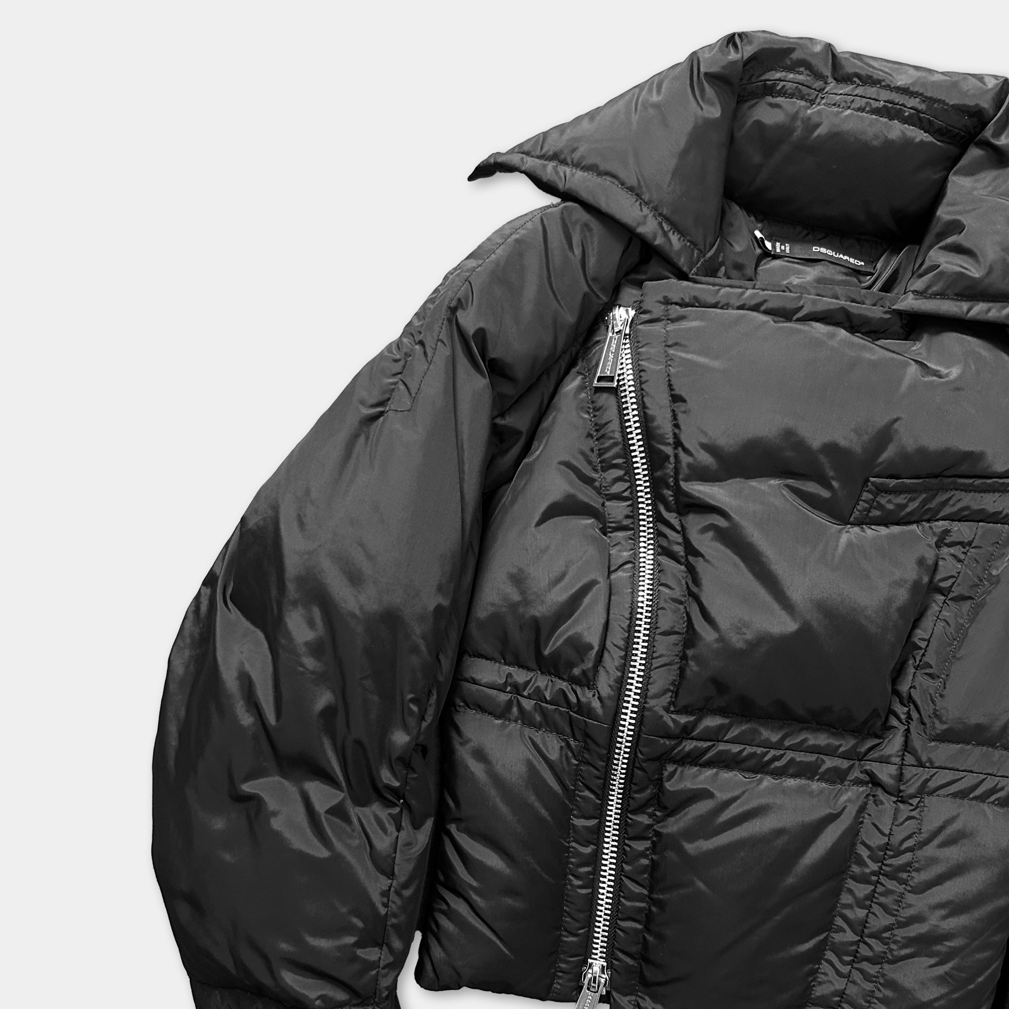 A black puffer jacket with a zipper and collar is shown against a white background.