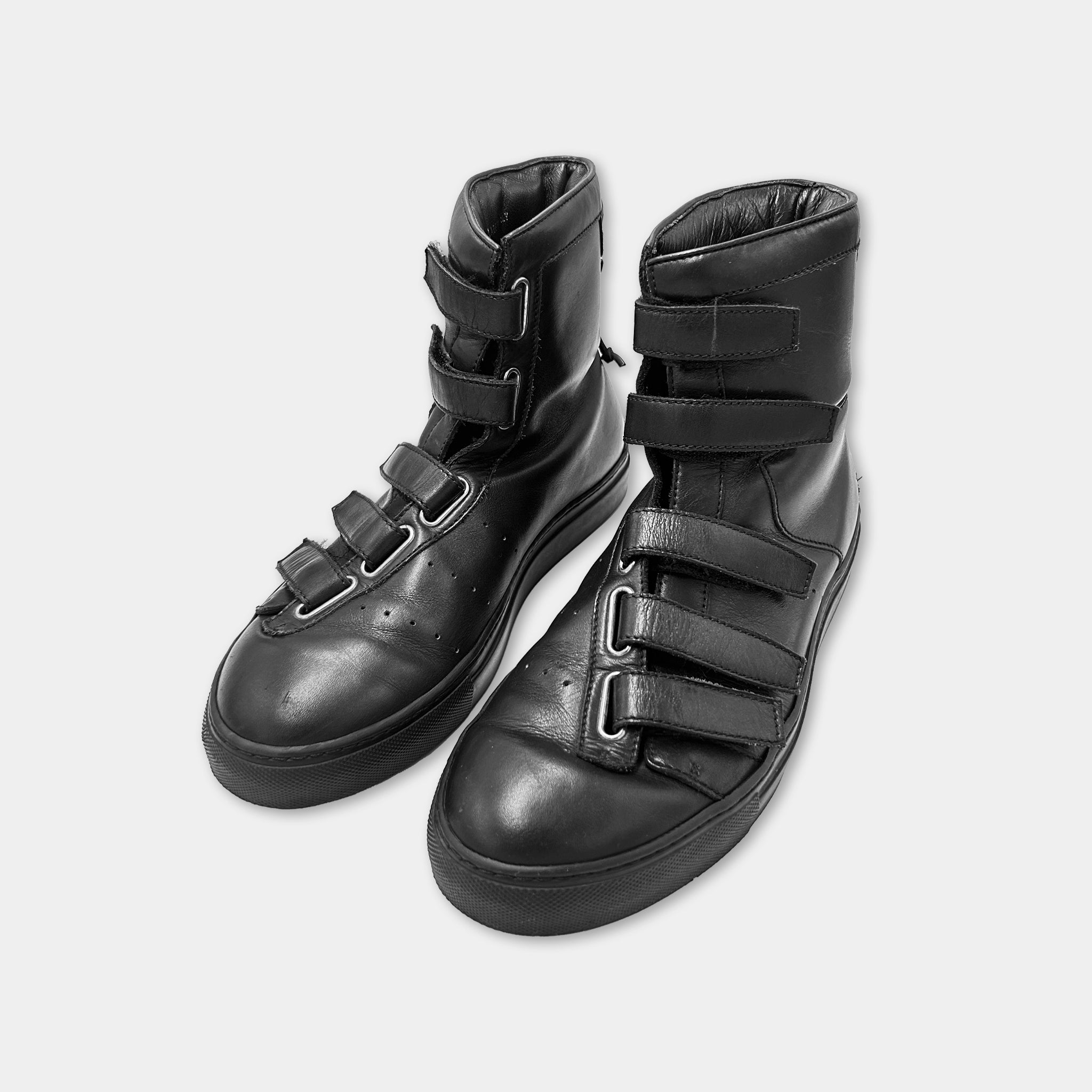 A pair of black leather boots with multiple straps and buckles.