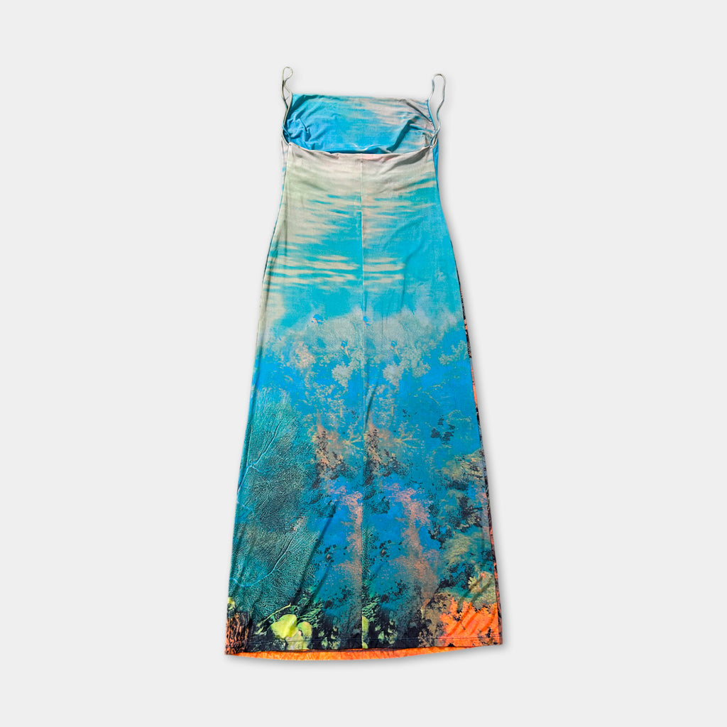 A colorful, patterned dress with a blue and green design, featuring a floral pattern and a tie at the neckline.