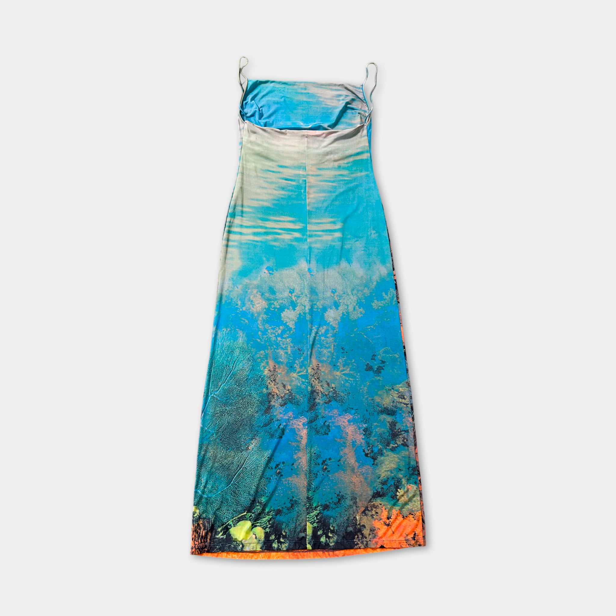 A colorful, patterned dress with a blue and green design, featuring a floral pattern and a tie at the neckline.