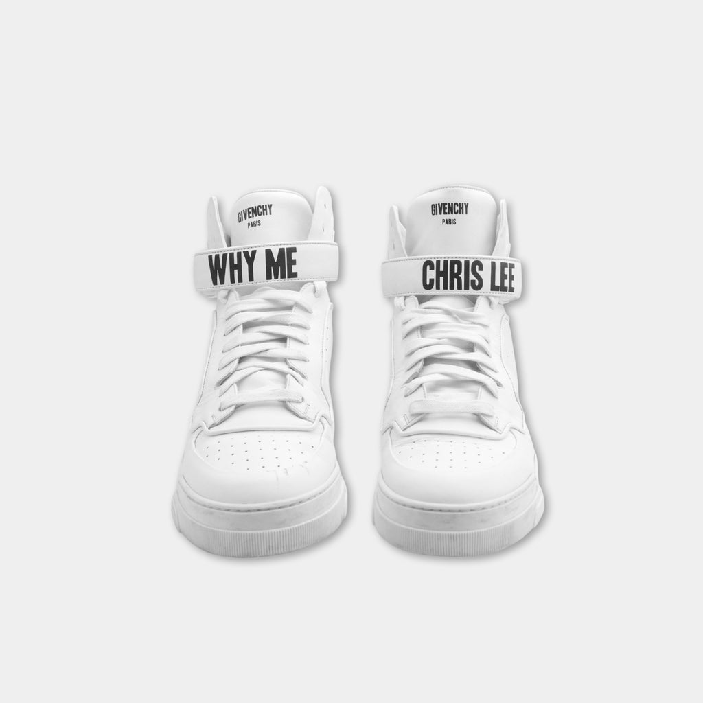 A pair of white sneakers with the text "WHY ME" and "CHRIS LEE" printed on them.