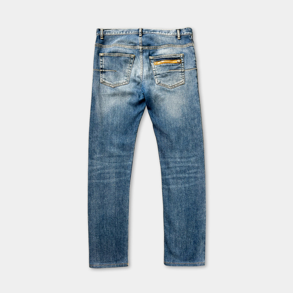 A pair of blue jeans with a yellow zipper pocket.