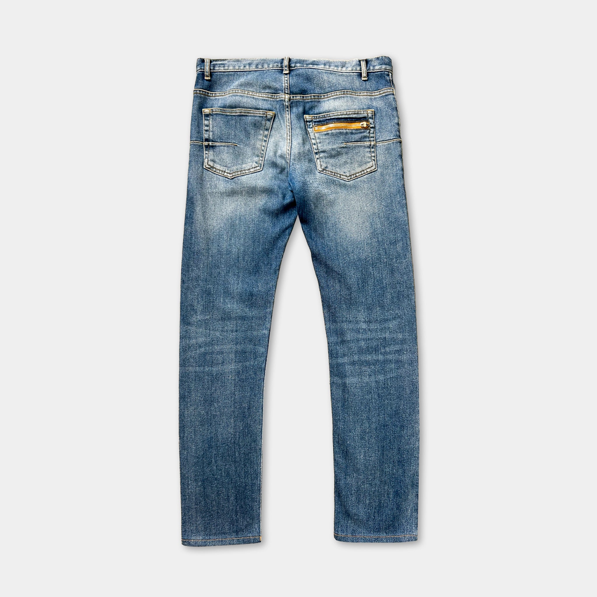 A pair of blue jeans with a yellow zipper pocket.