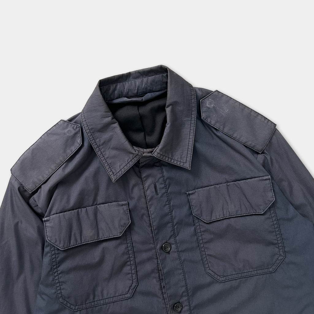 A dark-colored jacket with a collar and two pockets, displayed against a white background.