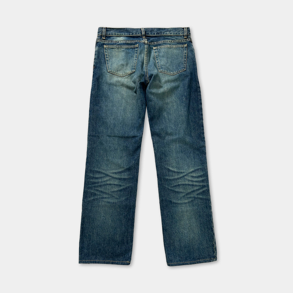 A pair of blue jeans with visible signs of wear and tear, including faded and wrinkled fabric.
