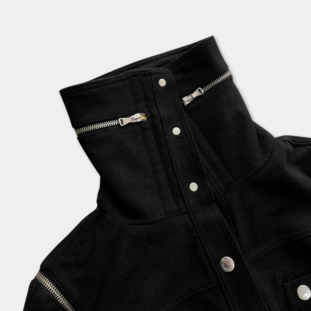 A close-up view of a black jacket with a high collar and two zippers on the front.