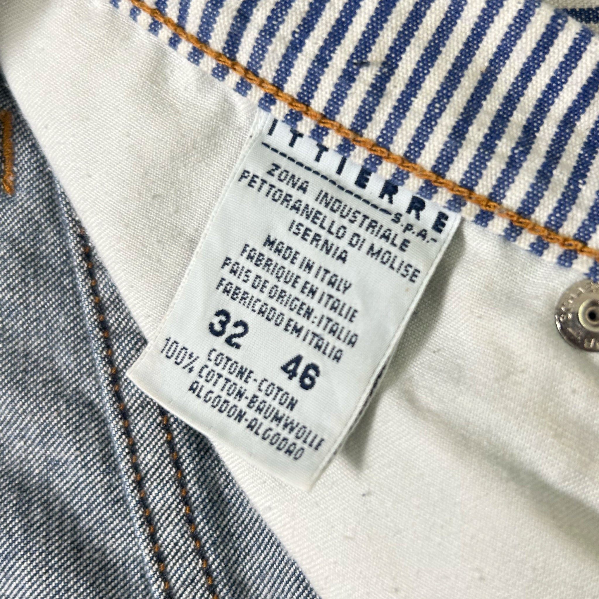 a close-up view of a label on a pair of jeans, with the label indicating the brand, material, and size of the jeans.