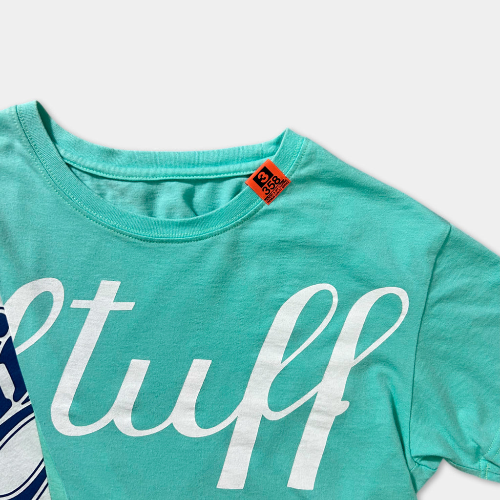 A turquoise t-shirt with the word "stuff" printed in white letters.
