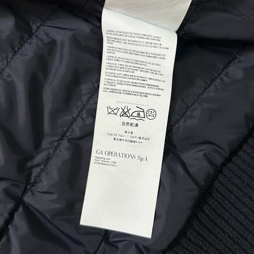 a close-up view of a black fabric with a label attached to it, which appears to be a garment or textile product.