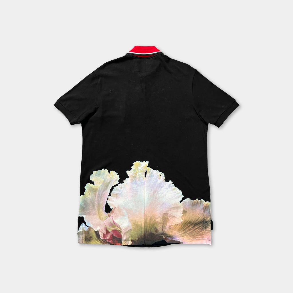 a black polo shirt with a red collar and a printed design of white and pink flowers on the back.