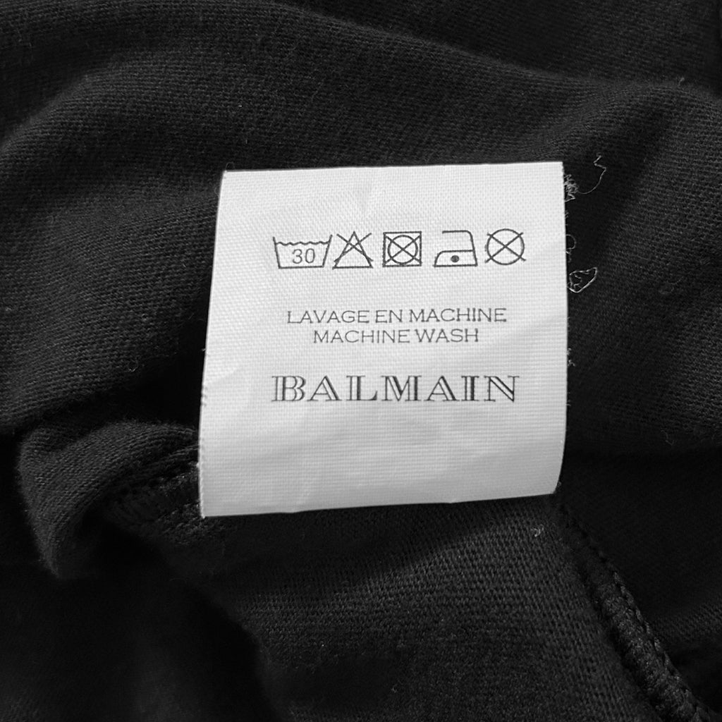 a close-up view of a black fabric with a label attached to it, which appears to be a garment or textile.