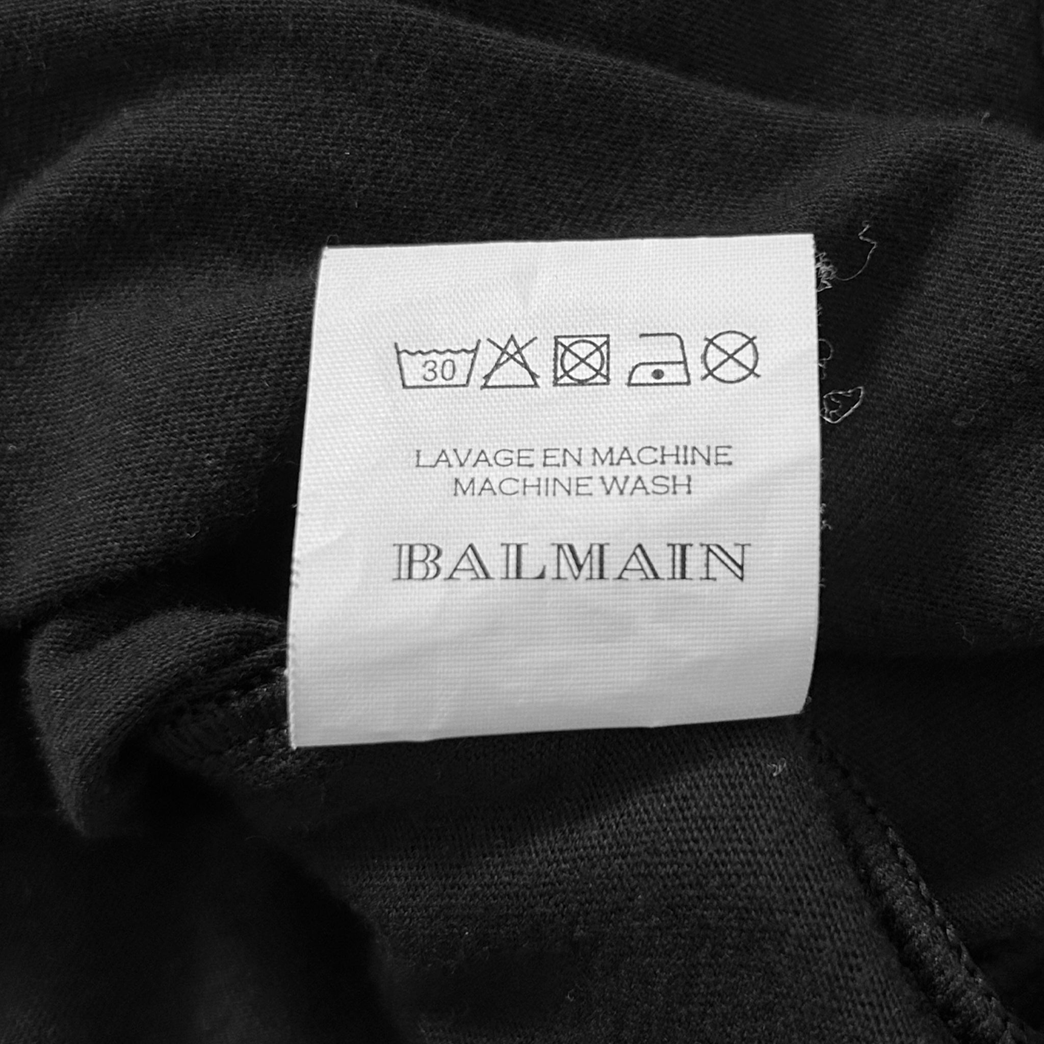 a close-up view of a black fabric with a label attached to it, which appears to be a garment or textile.