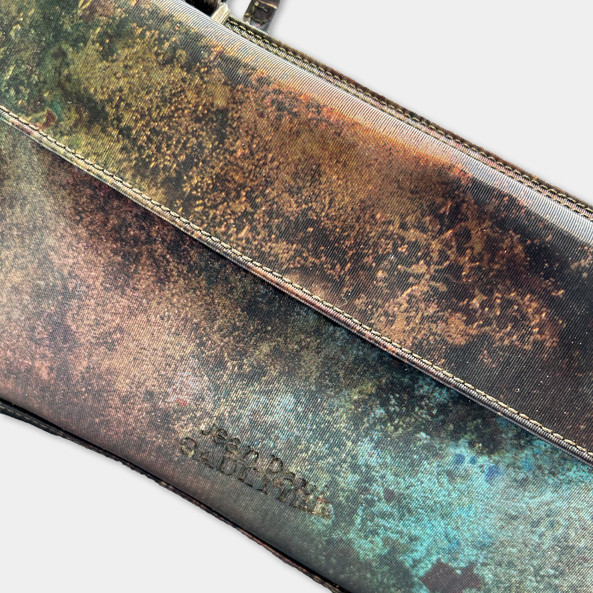 a close-up view of a textured, multicolored fabric or material, possibly a piece of clothing or accessory.