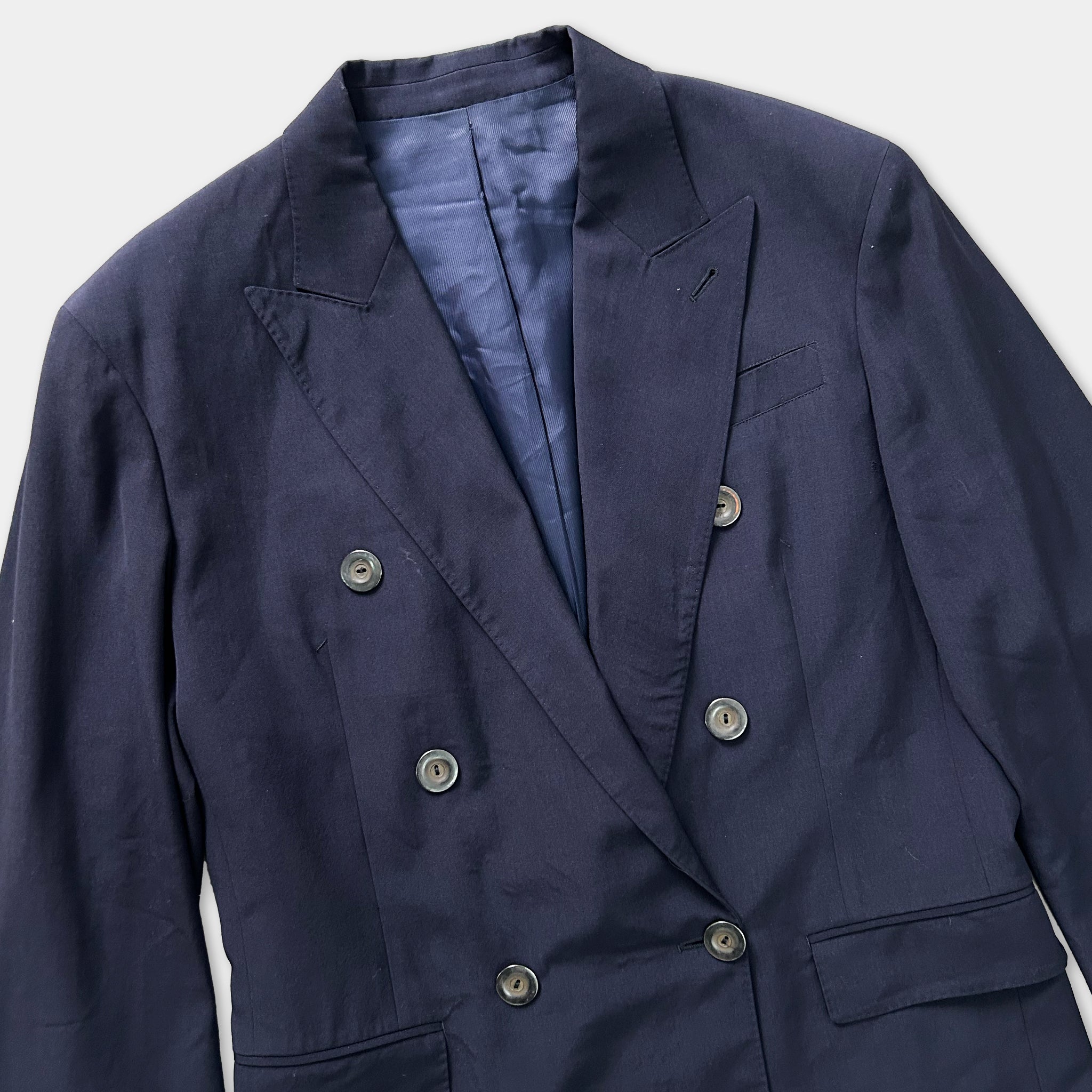 A navy blue double-breasted jacket with buttons and a blue lining.