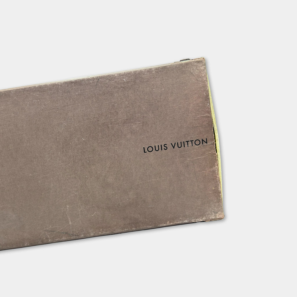 A close-up image of a brown box with the text "LOUIS VUITTON" printed on it.