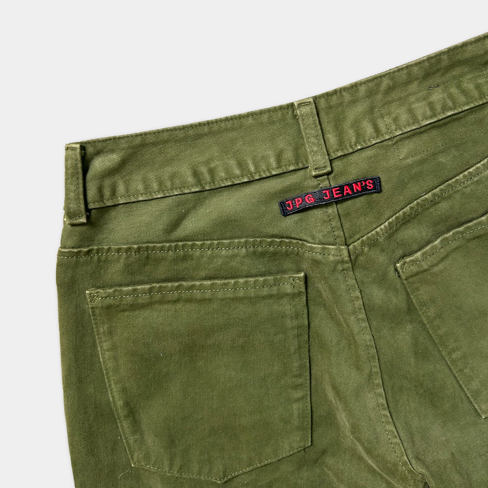 A pair of olive green cargo jeans with a red and black label on the back pocket.