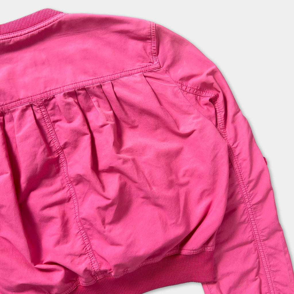 A close-up view of a bright pink jacket with a ruffled collar and sleeves.